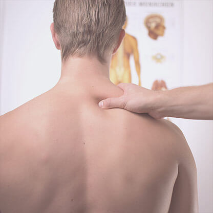 Man from behind, being acupressed on the right shoulder