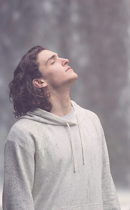 Relaxed man looks up with closed eyes