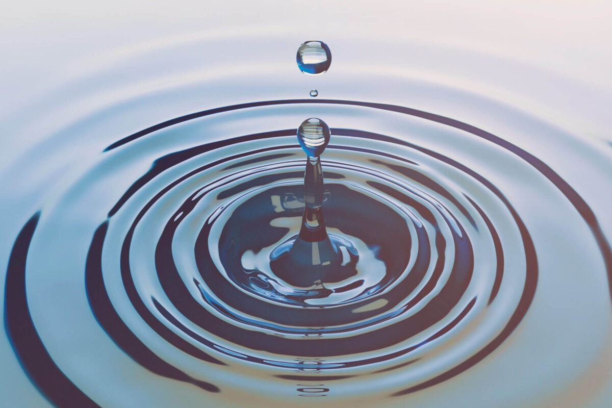 Water drop falls into the water and causes small waves